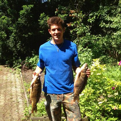 Gero Wurm hält in jeder Hand einen großen Fisch.