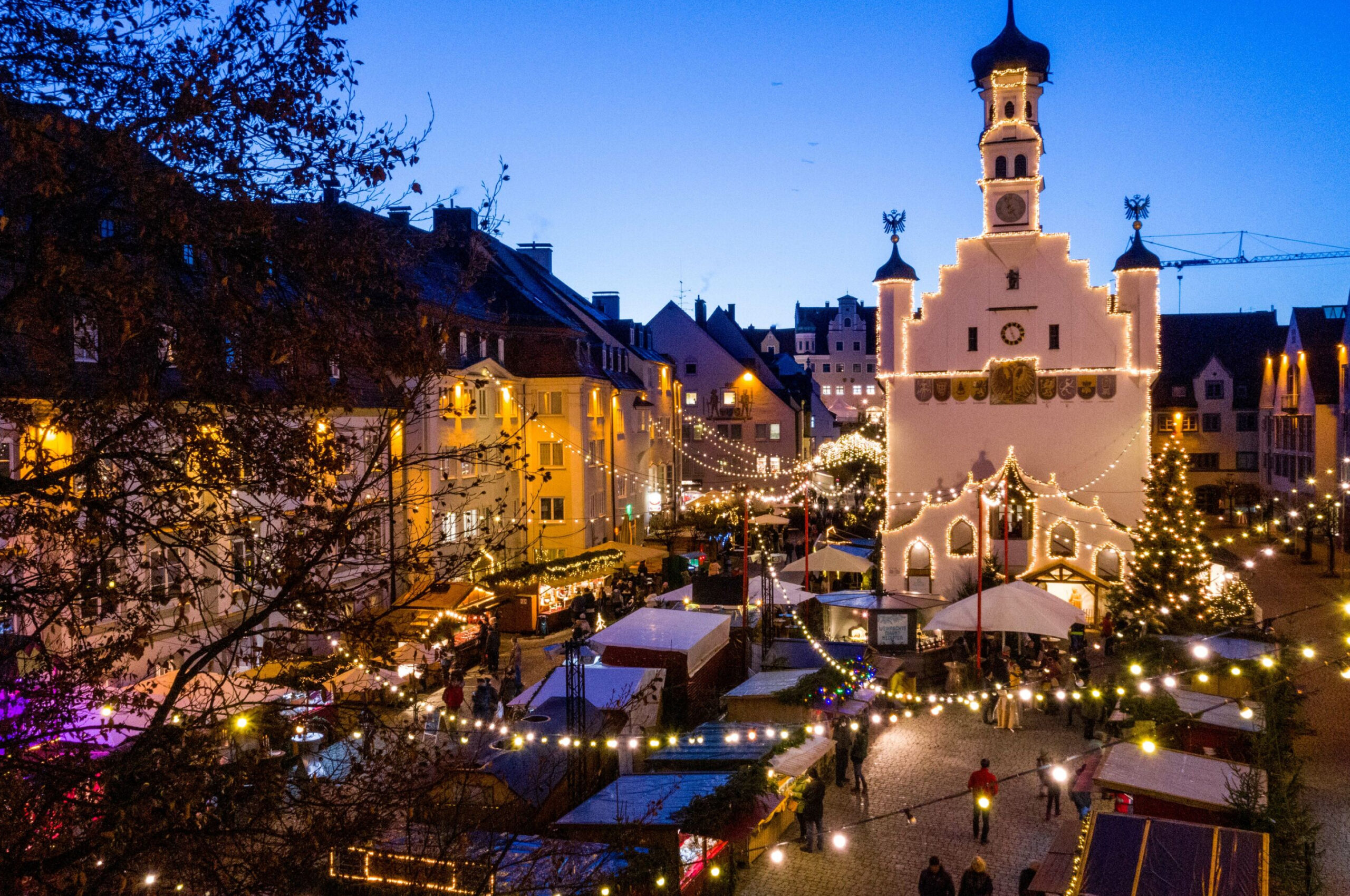 Weihnachtsmarkt mit vielen Lichterketten bei Nacht.