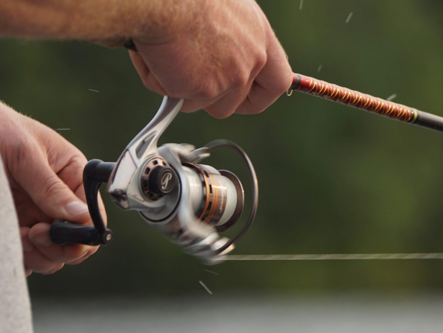 Nahaufnahme einer Angelrute, die eingeholt wird.